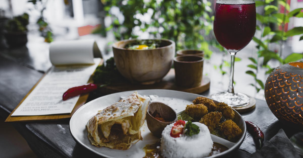 Pressure cooker rice quality vs high-end rice cooker - Plate with delicious Asian food and glass of refreshing beverage in cafe