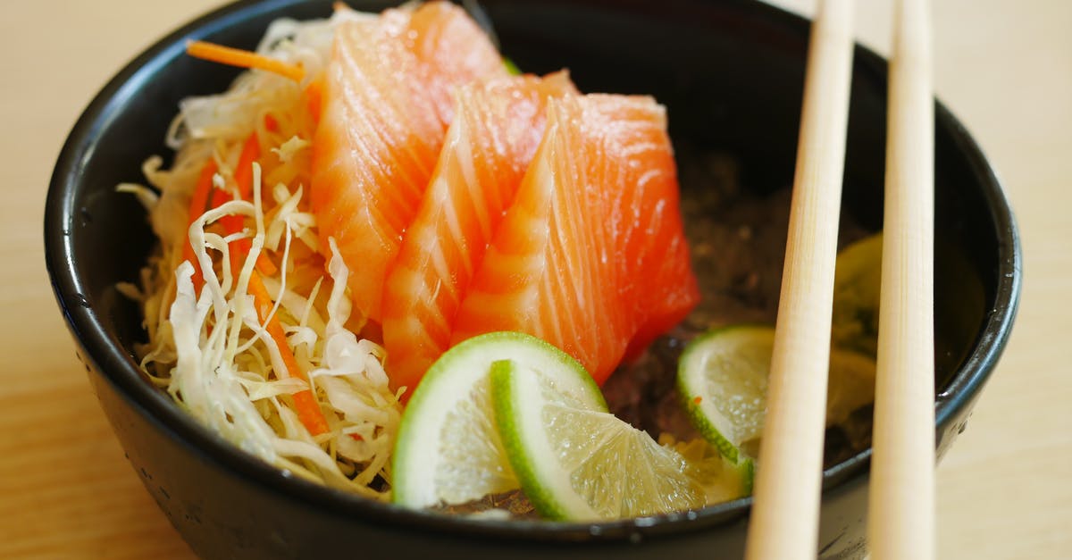 Process fresh salmon into Sushi / Sashimi salmon? - Slices of Salmon Sashimi with Slices of Lime on Black Bowl