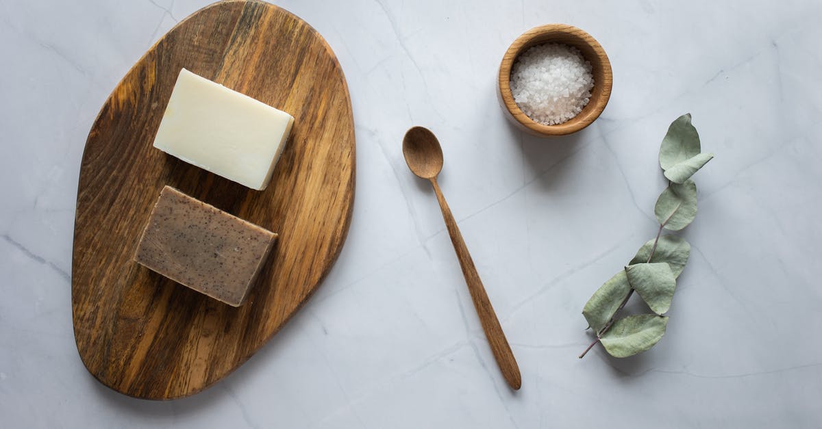 Proofing container: air tight vs simple bowl - Homemade soap on wooden board near scrub with salt