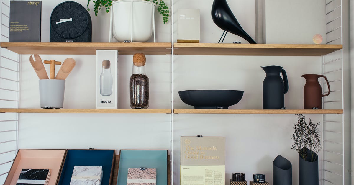 Proofing container: air tight vs simple bowl - Wooden shelves decorated with different vases and jugs with statue