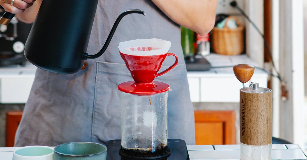 Proper grind and measurement for a pour over coffee maker - Crop anonymous female barista in apron preparing coffee using pour over coffee maker and drip kettle in light cafe