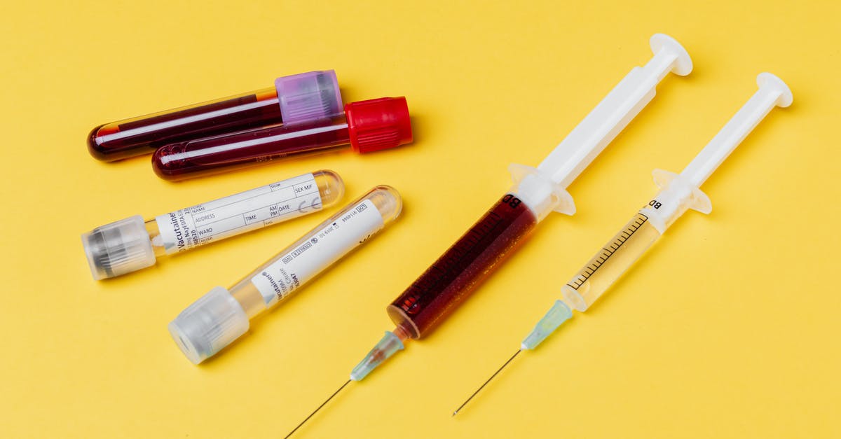 Pudding Control Sample measurements - From above of medical syringe with medication near injector with blood sample arranged with filled clinical test tubes placed on yellow background