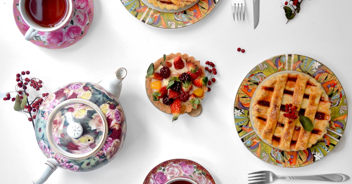 Puff Pastry vs Pie Crust - Top view of berry tarlet and fresh pies on white table with teapot near cutlery and mugs with hot tea