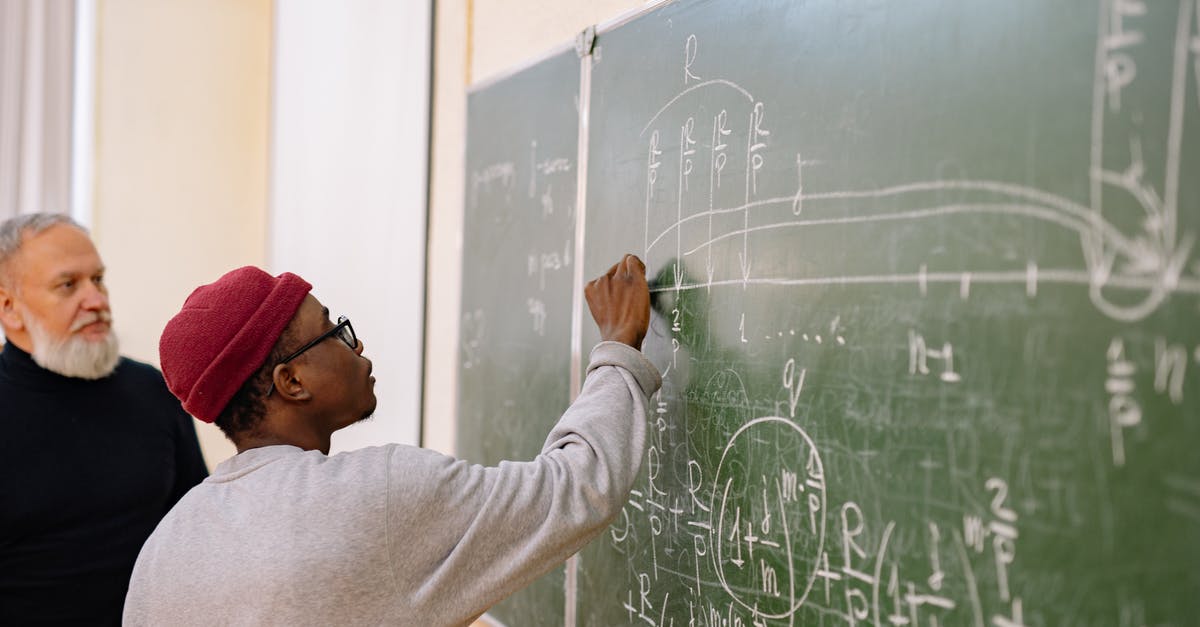 Questions about a recently purchased wok - Man in White Long Sleeve Shirt Writing on Chalk Board