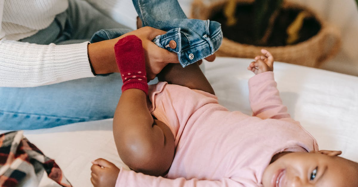 "Screaming" noise while steaming milk? - High angle of crop African American mother putting jeans on baby daughter crying on changing table