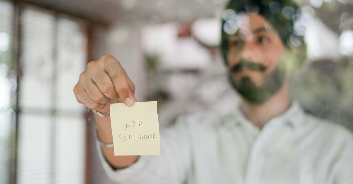 Recommend Indian cookbooks for a beginner/intermediate amateur [closed] - Indian man showing paper sheet while standing behind glass wall