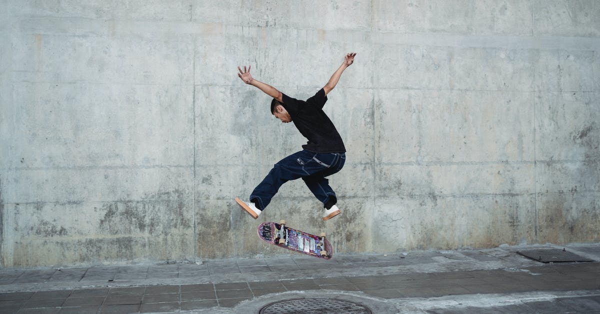 Recreating New York street vendors' "halal chicken over rice" - Young man jumping with skateboard above manhole near concrete wall