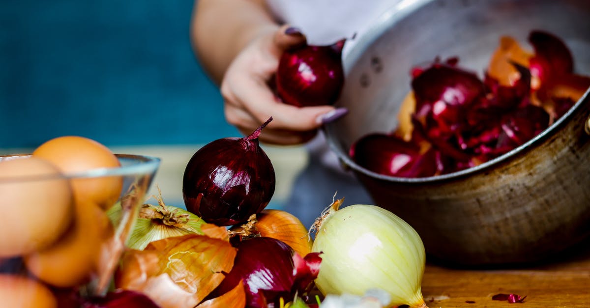 Red "white" onion? - Crop anonymous female peeling red and white onions into pan to naturally color Easter eggs for holiday