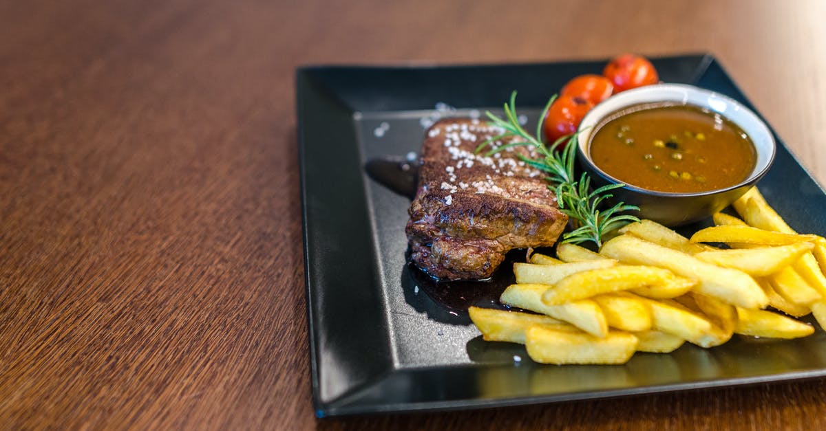 Reduce the watering from tomatoes in a dish or sauce - Grilled Beef With Fries and Sauce on Black Ceramic Plate