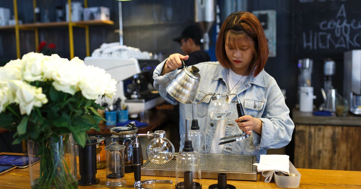 Reducing stock and then adding water - Woman Holding Kettle While Standing at the Table