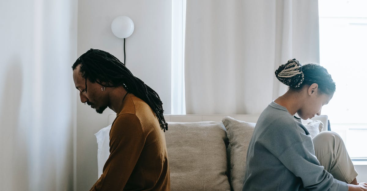 Refrigerate and separate patties - Side view unhappy sorrowful African American couple sitting on bed back to back after having argument