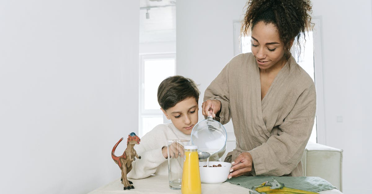 Refrigerating Clam Juice - Woman in Gray Long Sleeve Shirt Sitting Beside Woman in Gray Long Sleeve Shirt