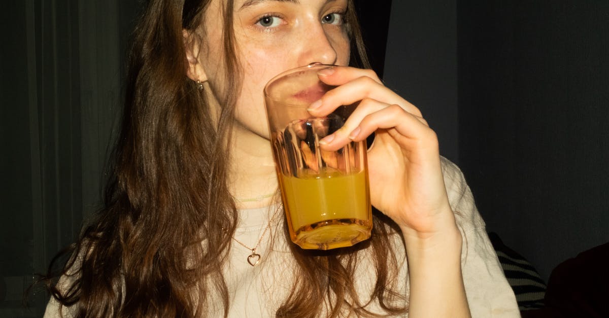 Refrigerating Clam Juice - Woman Holding Clear Drinking Glass