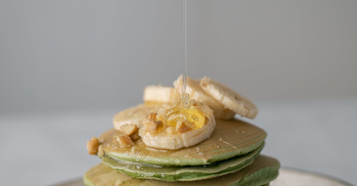 Relation between concentration of sugar in syrup VS its spoil rate - Appetizing sweet pancakes with honey and pieces of fresh banana on gray background