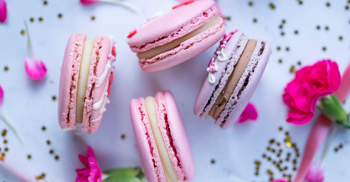 Reliable Cookie-to-Butter Ratio for Crumb Crusts - High angle of delicious sweet macaroons decorated with pink petals on table