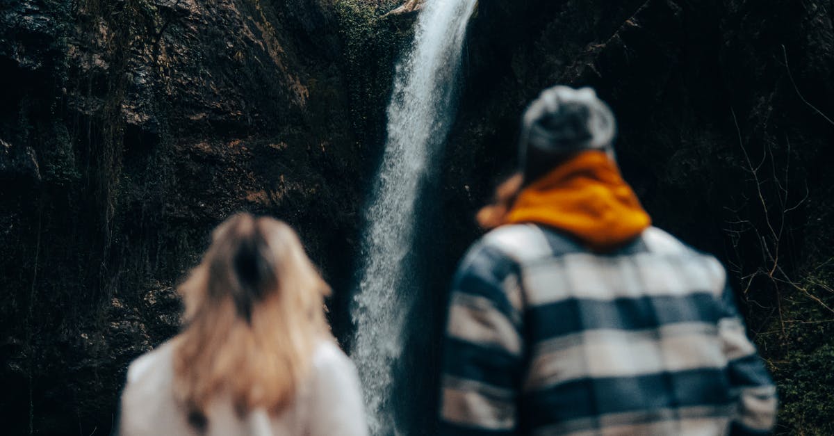 Removing hair from pork belly - Unrecognizable Couple Looking at Waterfall Coming from Rock