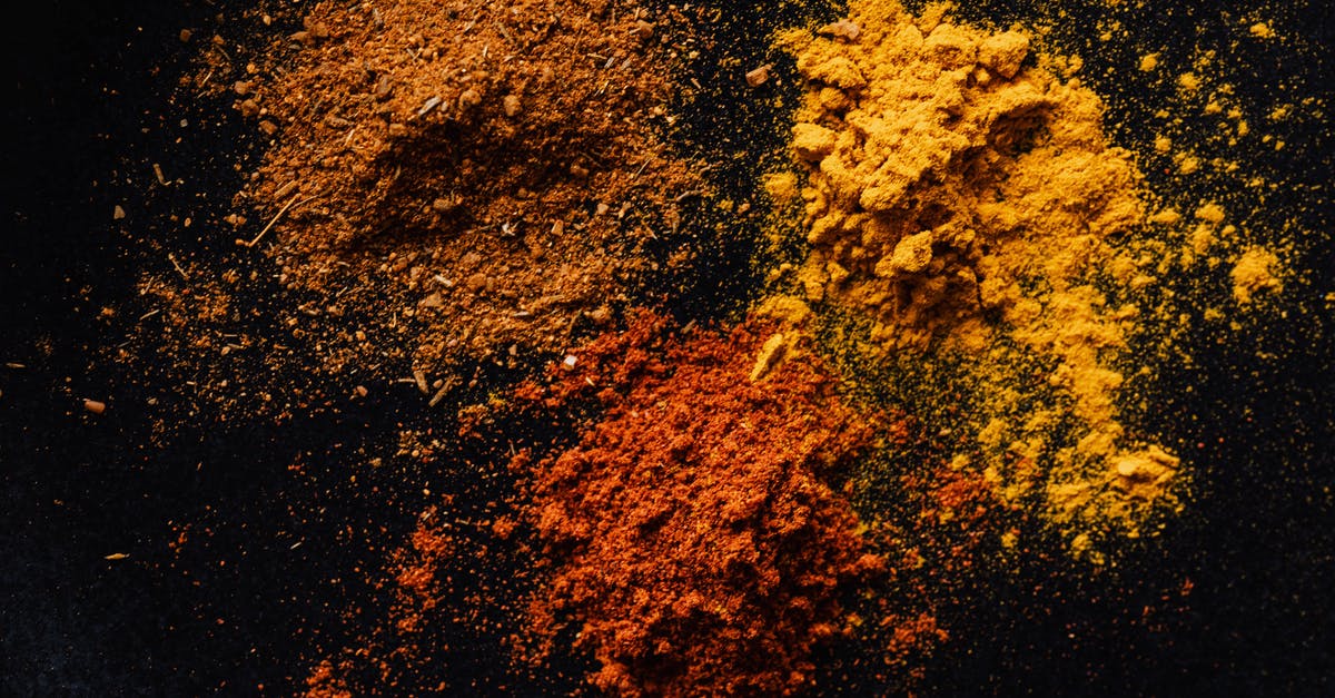 Removing turmeric colour from mortar and pestle - Assorted colorful dry powdered spices on black background