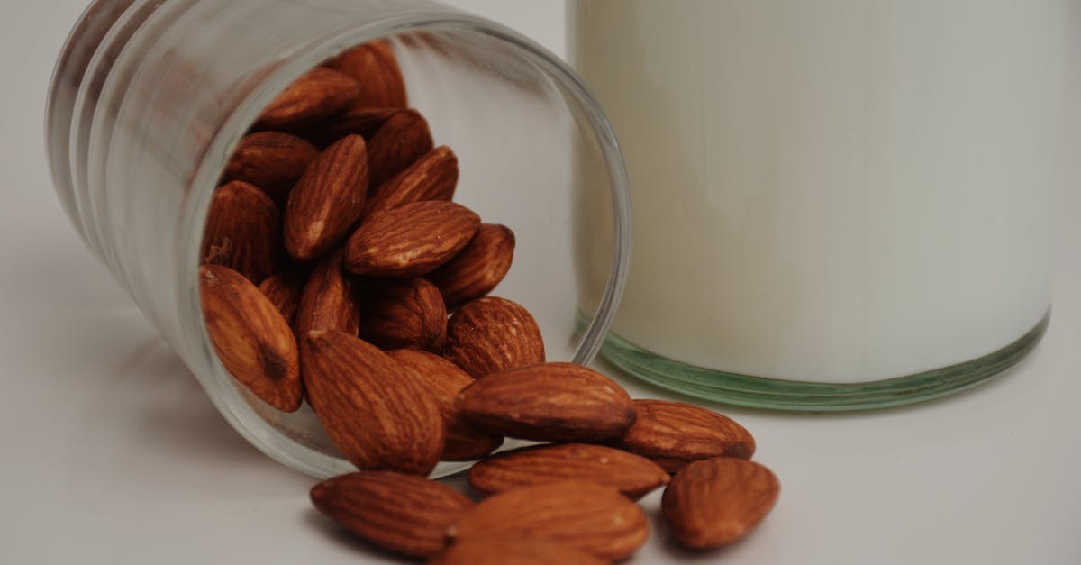 Replacement for Almond Milk - Fallen glass with crunchy almonds near milk