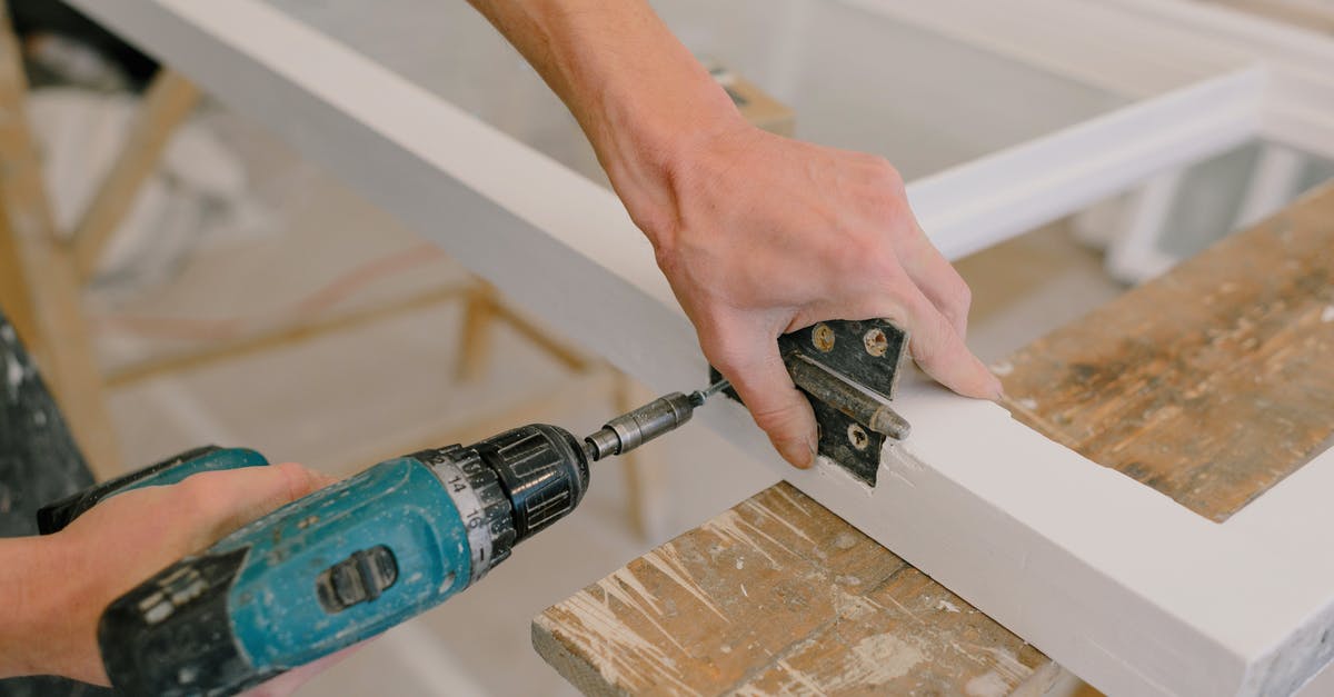 Replacement for Appenzeller? - Unrecognizable professional male master using cordless screwdriver to install metal hinge on wooden window in light room during repair works