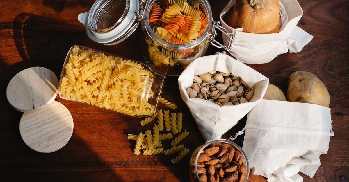 Replacement for pasta that is natural and fairly low carb - Top view jars of raw pasta placed on wooden table near ECO friendly sacks with pistachios and almonds near pumpkin and potatoes