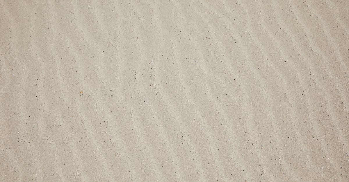 Replacing dry white wine with bubbly - Top view of empty dry plain surface of beach covered with sand in daytime