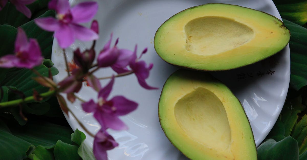Rescuing a CUT but unripe avocado - Sliced Avocado on White Ceramic Plate