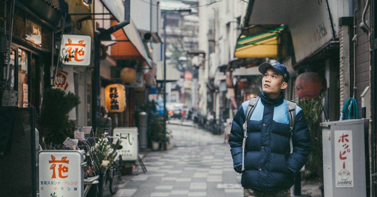 restaurants terms - Man Walking on Grey Concrete Alley Surrounded by Buildings