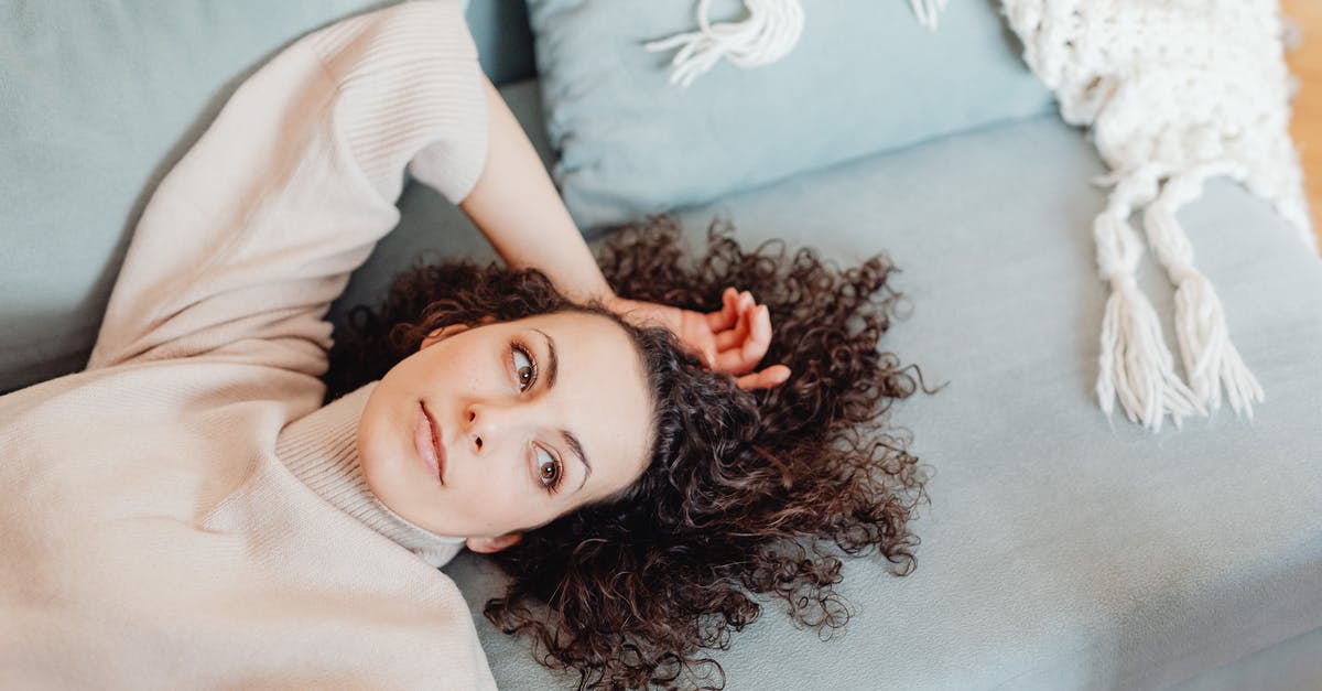 Resting for brownie batter - Woman in Turtle Neck Sweater Lying Near the Throw Pillows while Looking Afar