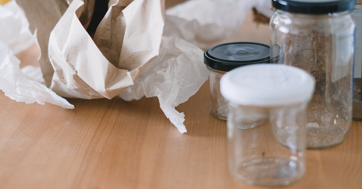 Reusing butter used as a frying agent - Glass jars and crumpled paper on wooden table