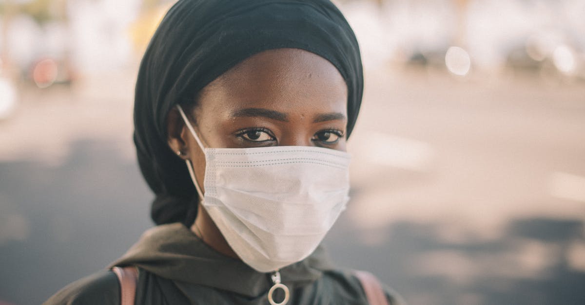 Ribs safety after outside defrosting [duplicate] - Unrecognizable young ethnic woman in jacket and headscarf and protective mask standing on city street