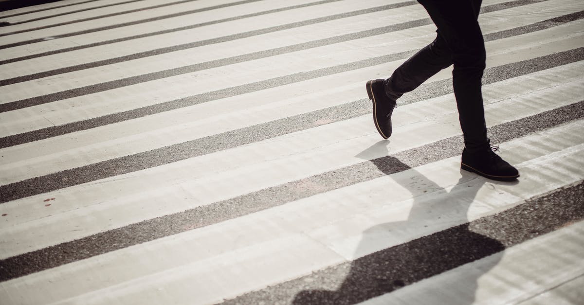 Ribs safety after outside defrosting [duplicate] - Crop faceless person in elegant black trousers and shoes walking on crosswalk in daytime