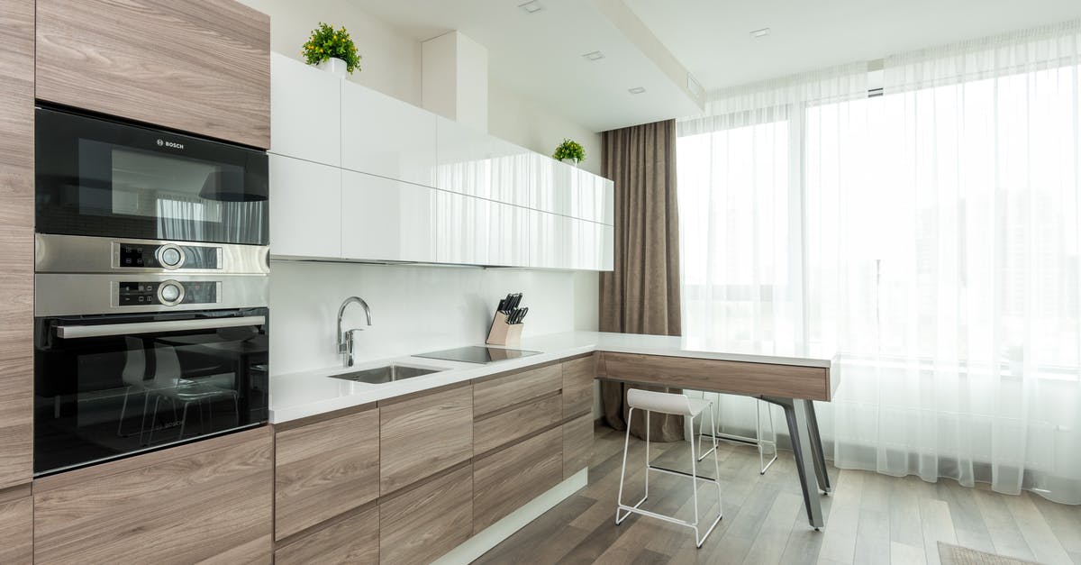 Rigging equipment for steaming large amounts at once - Interior of modern light kitchen with white and wooden cabinets and contemporary appliances in apartment