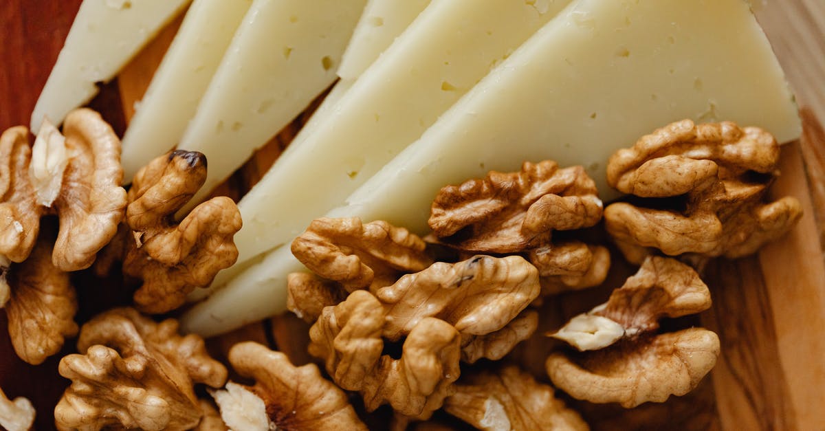 Roasting nuts in a rotisserie drum - Sliced Cheese and Roasted Walnuts on Wooden Board