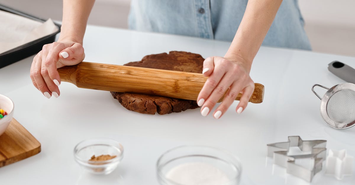 Rolling out after or before the leavening process? - Person Flattening a Chocolate Dough With Rolling Pin