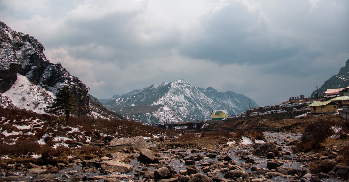 Rough guidelines for oven temperatures - Rocks on frozen ground near village with houses located in mountainous terrain covered with snow against overcast sky on winter day