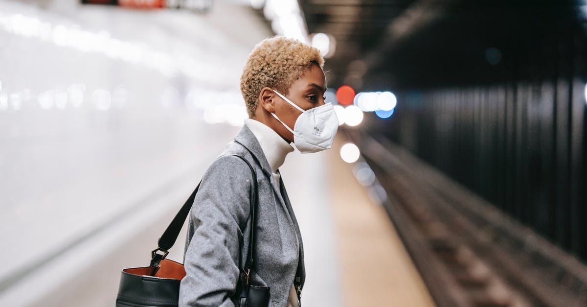 Royal icing safety concern - Pensive black woman in mask standing on railway platform