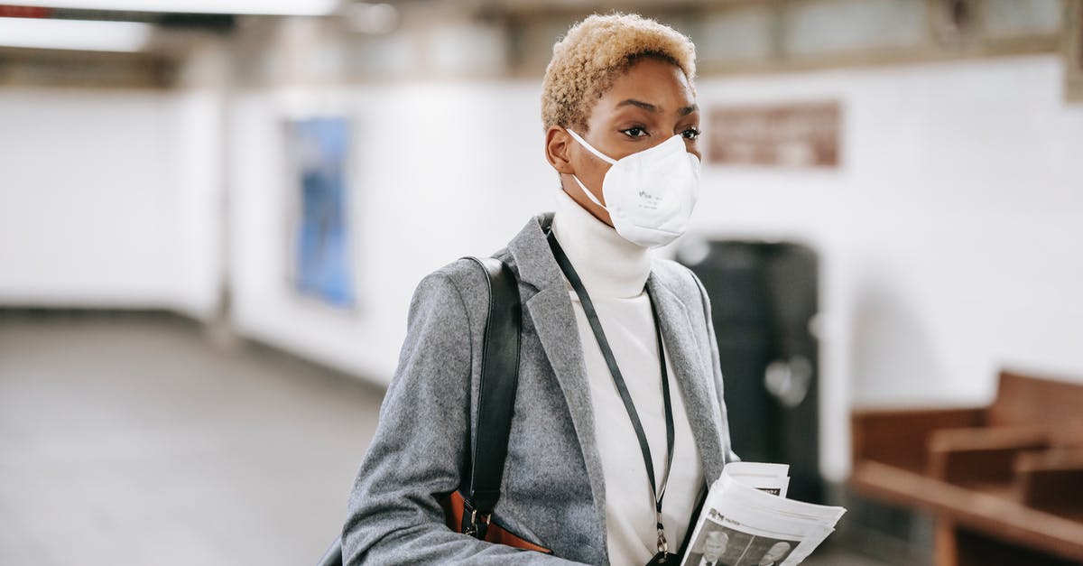 Royal icing safety concern - Pensive black woman with newspaper standing in public hallway