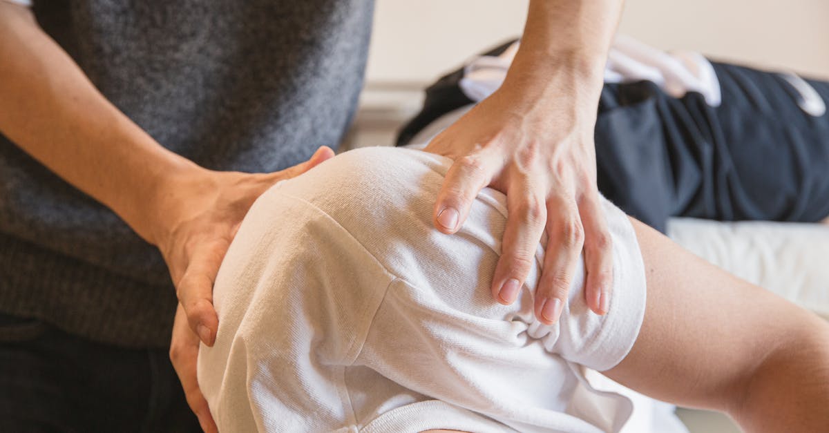 Rub Roast Before or After Searing? - Crop anonymous medical specialist rubbing shoulders of male client lying on couch in medical salon