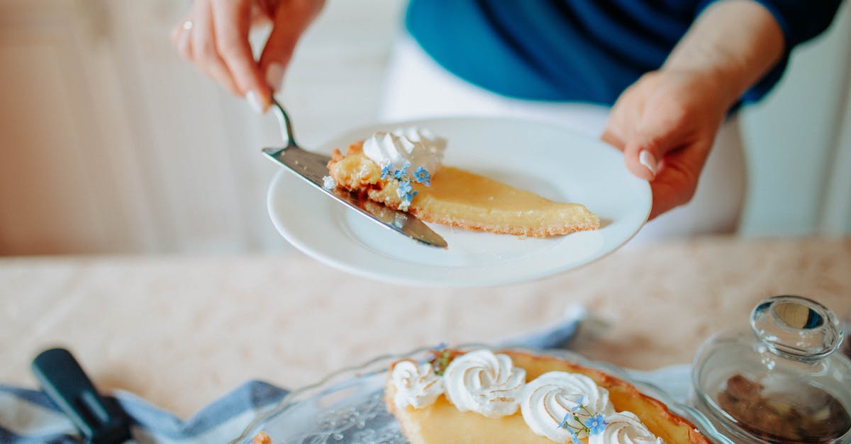 Russian Pie Recipe breaks into little pieces? - Anonymous woman with cake on plate near table in kitchen