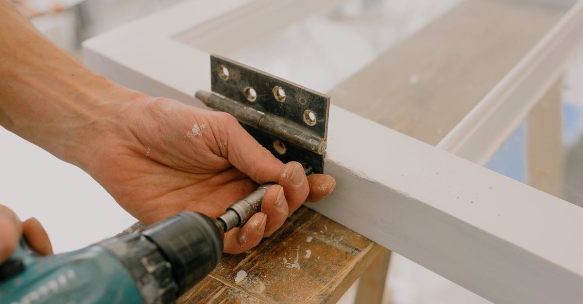 Safe kitchen-ready materials to drill holes in for tofu press? - Crop unrecognizable worker drilling metal hinge on white window frame during house renovation