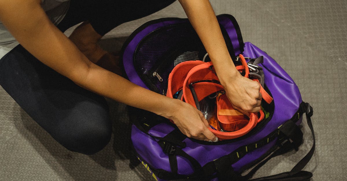 Safe to put honeycomb in tea? - From above of crop anonymous female athlete sitting on floor and packing safety belt in bag after training in contemporary gym