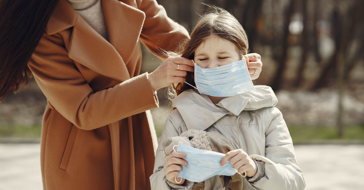 Safe to put honeycomb in tea? - Crop female helping to put on medical mask for daughter during stroll in nature