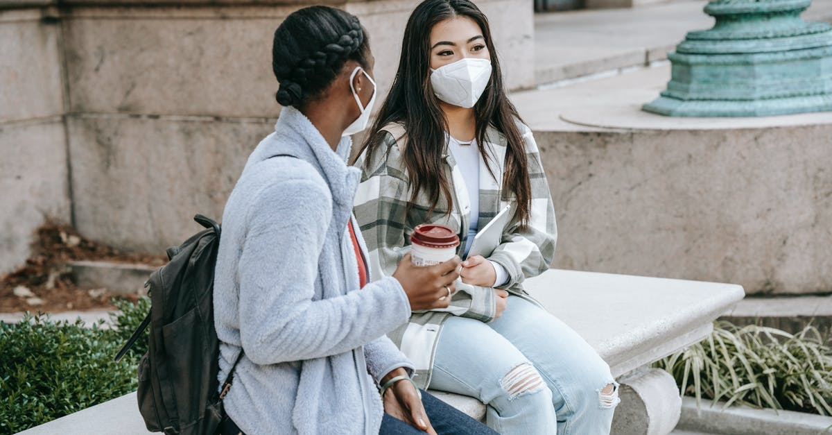 Safety of coffee in thermal flask, long periods of time - Multiethnic girlfriends sitting in street in masks