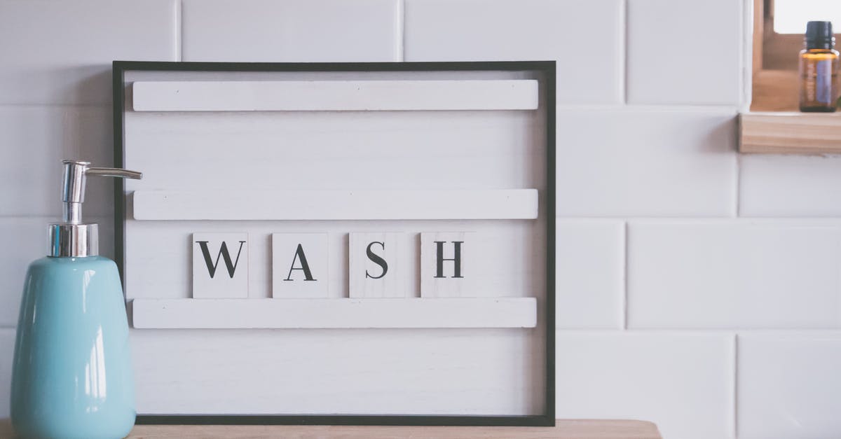 Sanitization, disinfection, sterilization of Dishwasher? - Board with word WASH placed near soap dispenser on counter in light bathroom representing concept of hygiene and coronavirus prevention