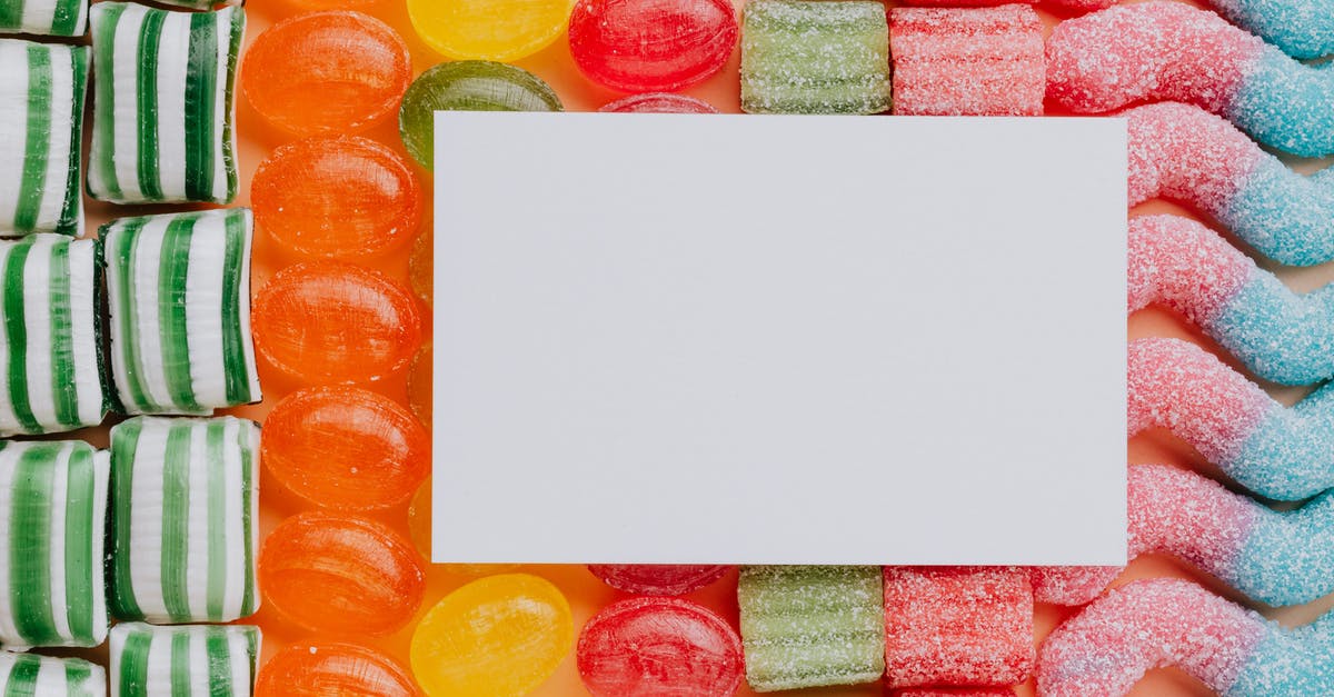 Sautéing vs Frying vs Caramelizing -- what's the difference? - Top view closeup of blank paper card placed on multicolored various shapes yummy candies in light confectionery