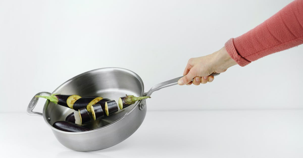 Searing Tofu in Stainless Skillet - Person Holding Stainless Steel Casserole