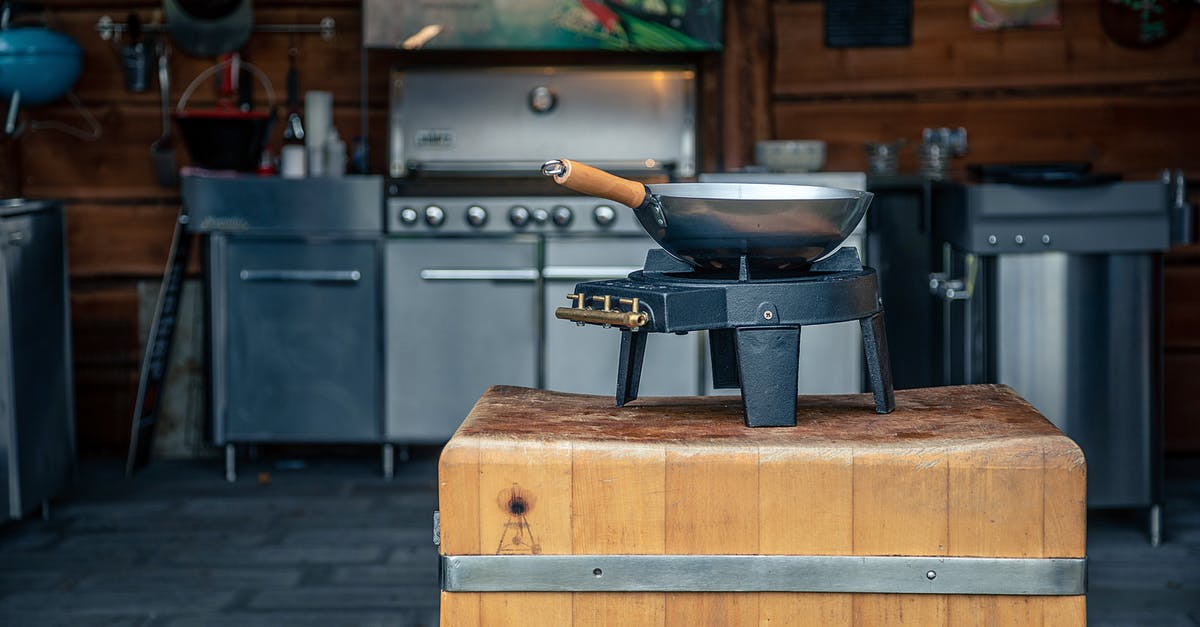 Seasoning a carbon steel wok - A Stainless Wok  with Wooden Handle on a Gas Stove 