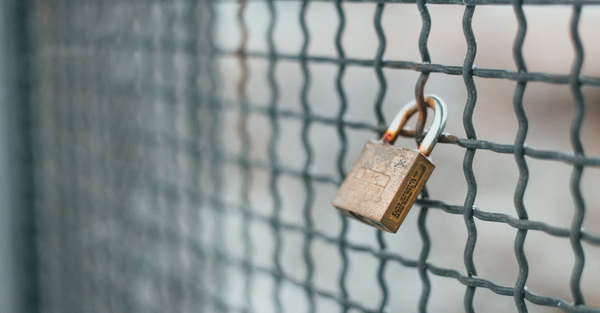 Seasoning old non-stick aluminum pan? - Small iron lock hanging on rusty metal grid for protection and safety of private area