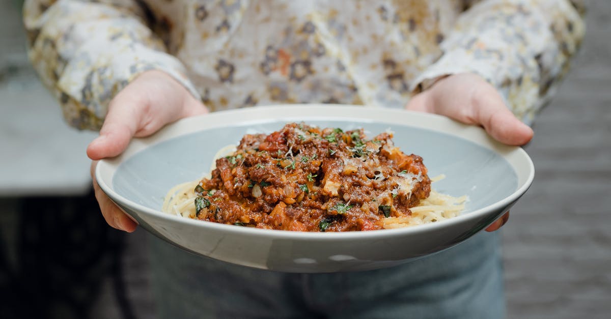 secret ingredient in a restaurant bolognese - Crop faceless young waitress in casual clothes offering plate of appetizing spaghetti bolognese in bowl