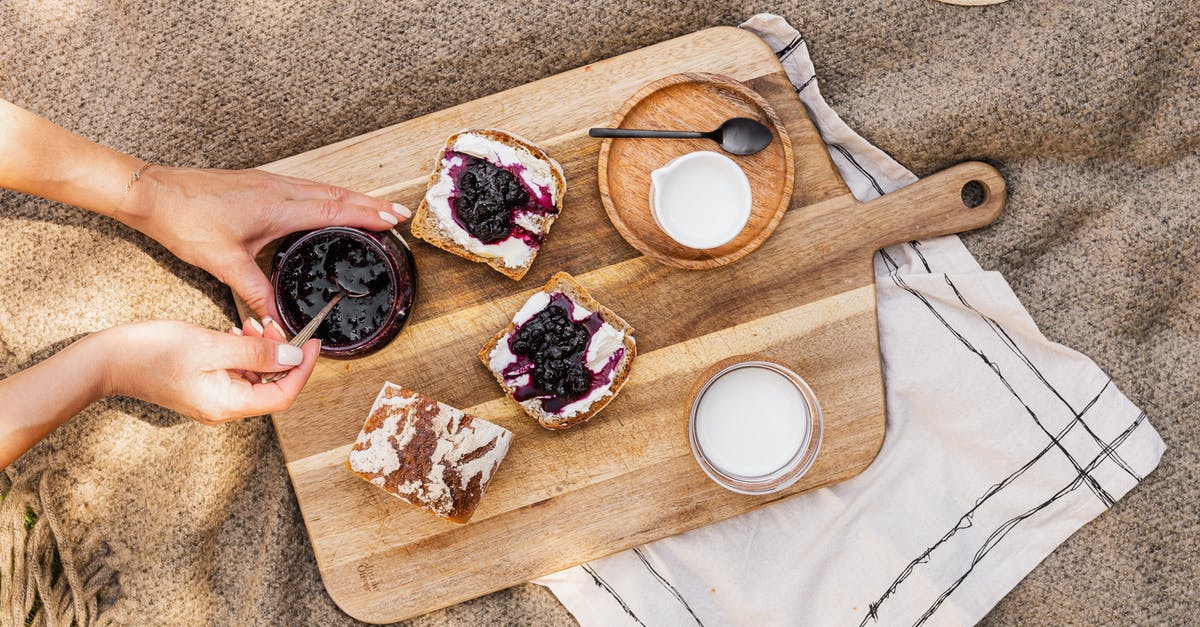 Seedless blueberry jam - consistency - Person Holding Brown Wooden Chopping Board With Sliced of Bread